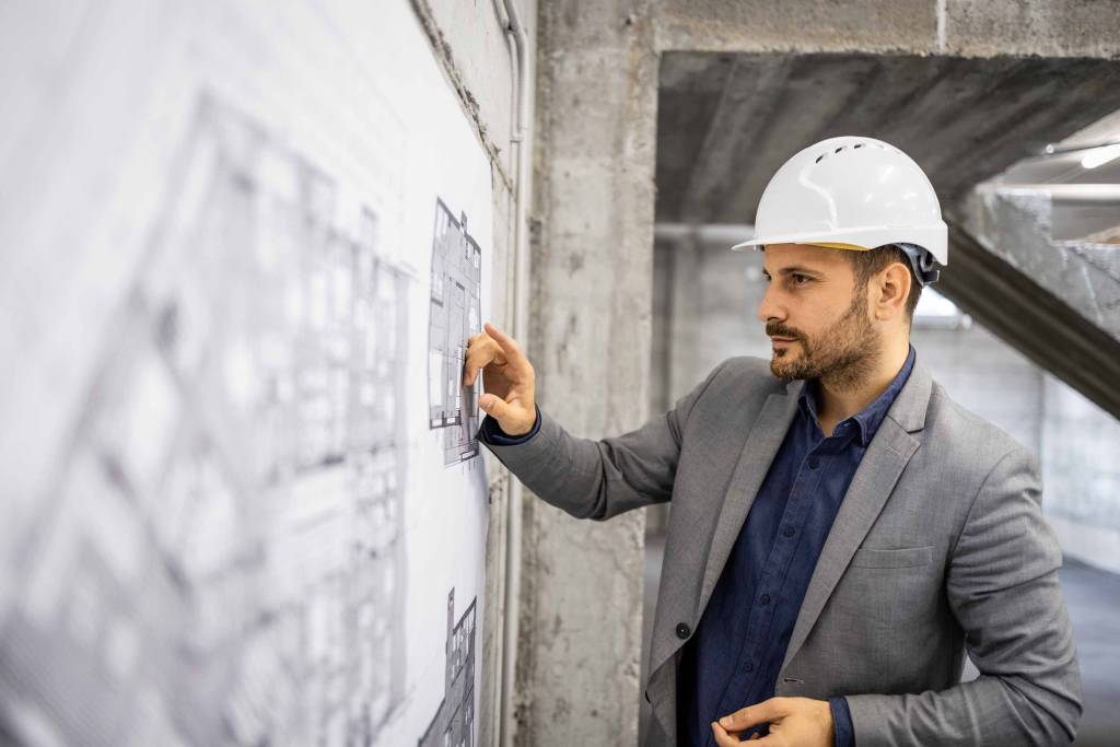 arquitecto dirigiendo obra sobre plano